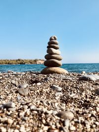 Stack of stones on beach against clear sky