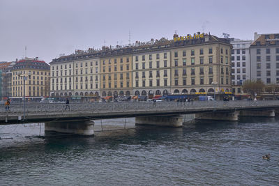 Bridge over river against buildings in city
