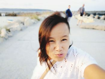 Close-up of woman puckering while standing on promenade