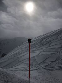 Snow covered land and mountains against sky