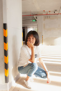 Portrait of woman crouching on floor