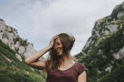 Midsection of woman standing on rock against mountain