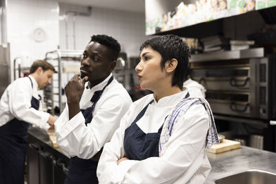 Male and female colleagues brainstorming in restaurant kitchen