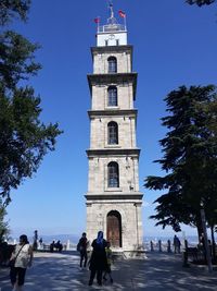 People in front of building against sky