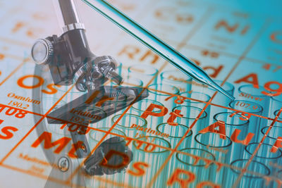 Digital composite image of periodic table over microscope and test tubes