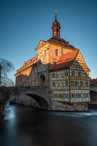 Arch bridge over river against buildings
