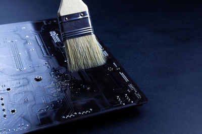 High angle view of paintbrushes on table against black background