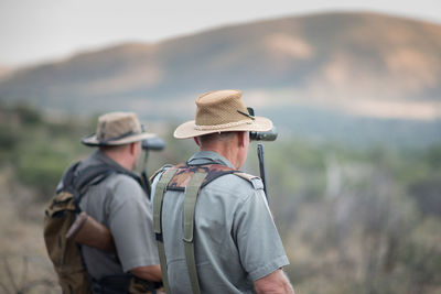 Rear view of men standing outdoors