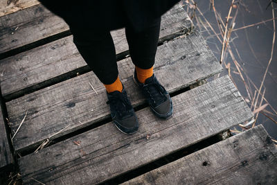 Low section of woman standing on boardwalk