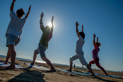 People enjoying at beach against clear sky