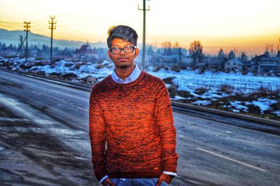 Full length of man standing in snow against sky during sunset