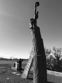 Statue on field against clear sky