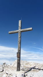 Close-up of cross against blue sky