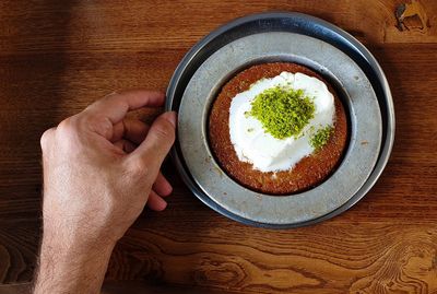 High angle view of hand holding food on table