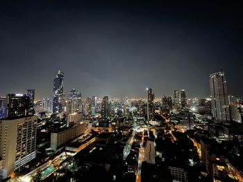 Illuminated cityscape against sky at night