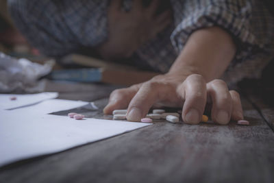 Man grabbing pills while lying on floor