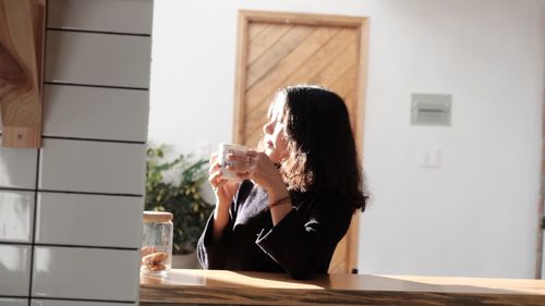 Woman having coffee at home