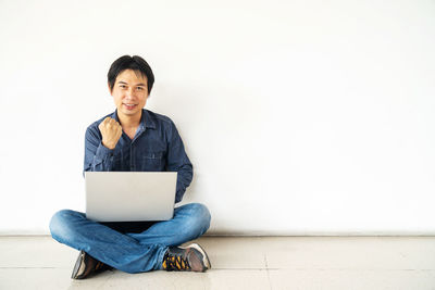 Portrait of smiling young man using mobile phone