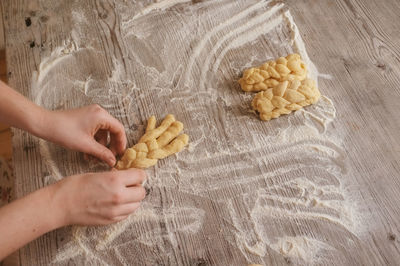 Cropped image of hand making breads on table