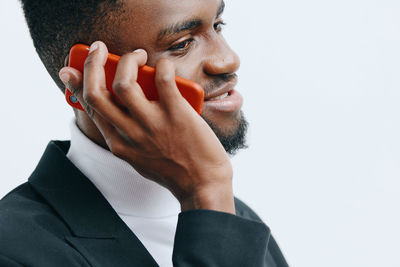 Side view of man looking away against white background