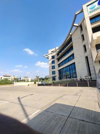 Street by buildings against blue sky