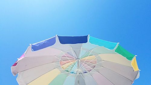 Low angle view of umbrella against clear blue sky