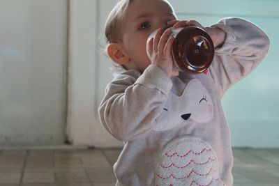 Baby girl drinking at home