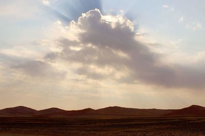 Scenic view of mountains against cloudy sky