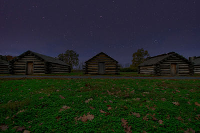 House on field against sky at night