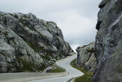 Scenic view of mountain road against cloudy sky