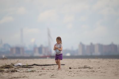 Girl on beach against sky