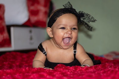 Cheerful baby girl on bed