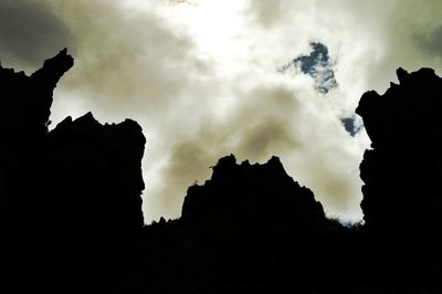 Low angle view of silhouette tree against cloudy sky