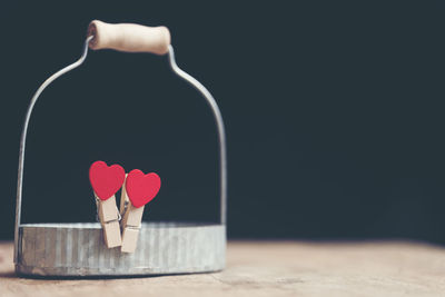 Close-up of red heart shape on table against black background