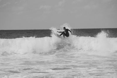 Man surfing on sea against sky