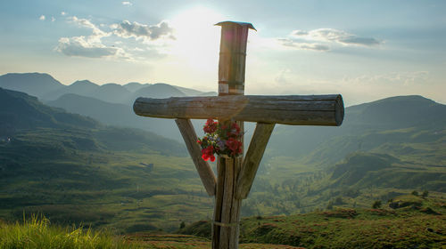 Scenic view of cross on land against sky