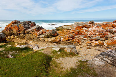 Rock formation on beach against sky