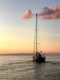 Silhouette ship sailing on sea against sky during sunset