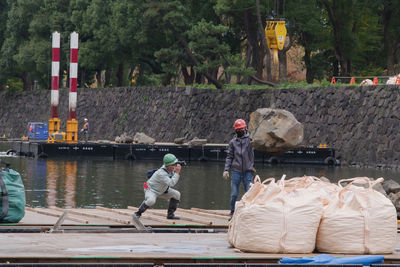 People working in boat against trees