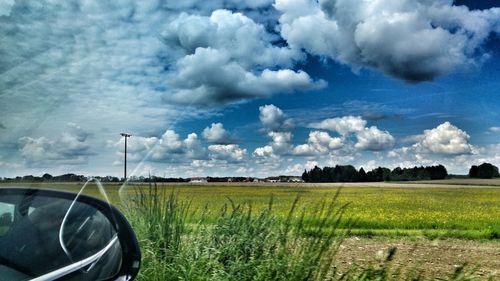 Scenic view of field against cloudy sky