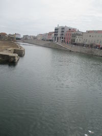 River by cityscape against sky