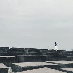 Man standing on steps against sky