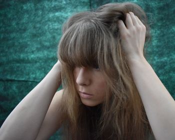 Close-up of young woman with hand in hair
