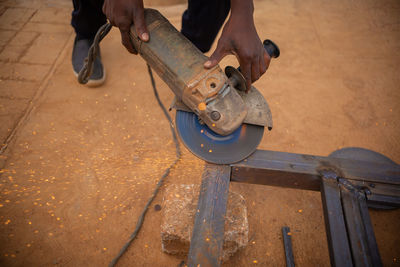 Low section of man working on metal