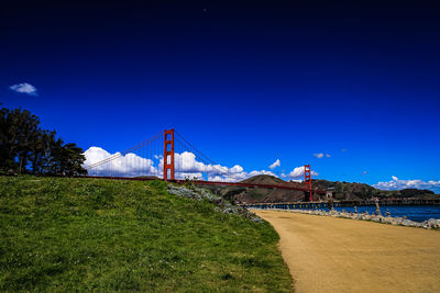 View of suspension bridge against blue sky
