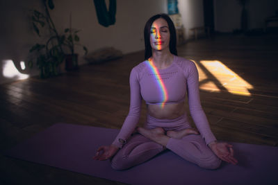 Full length of woman meditating at home