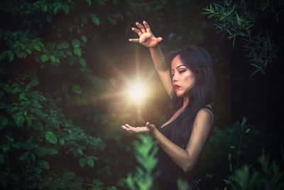 Young woman standing by plants