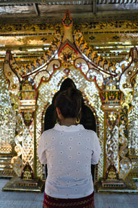 Rear view of woman standing in temple