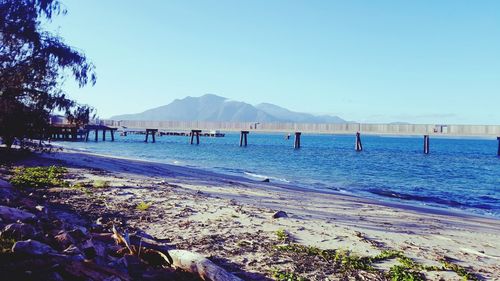 Scenic view of beach against clear blue sky