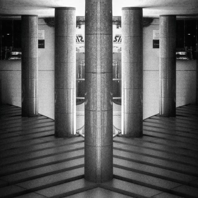 indoors, architecture, built structure, architectural column, column, in a row, empty, illuminated, railroad station, window, no people, flooring, repetition, building, modern, ceiling, absence, railroad station platform, interior, corridor